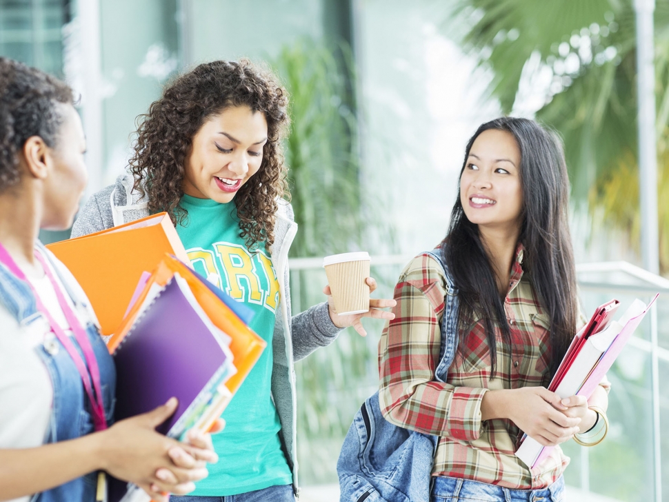 University students walking with books and coffee