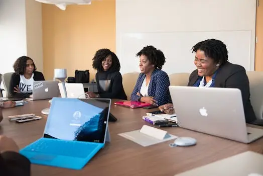 Group of People Talking to Each Other in Front of Brown Wooden Table